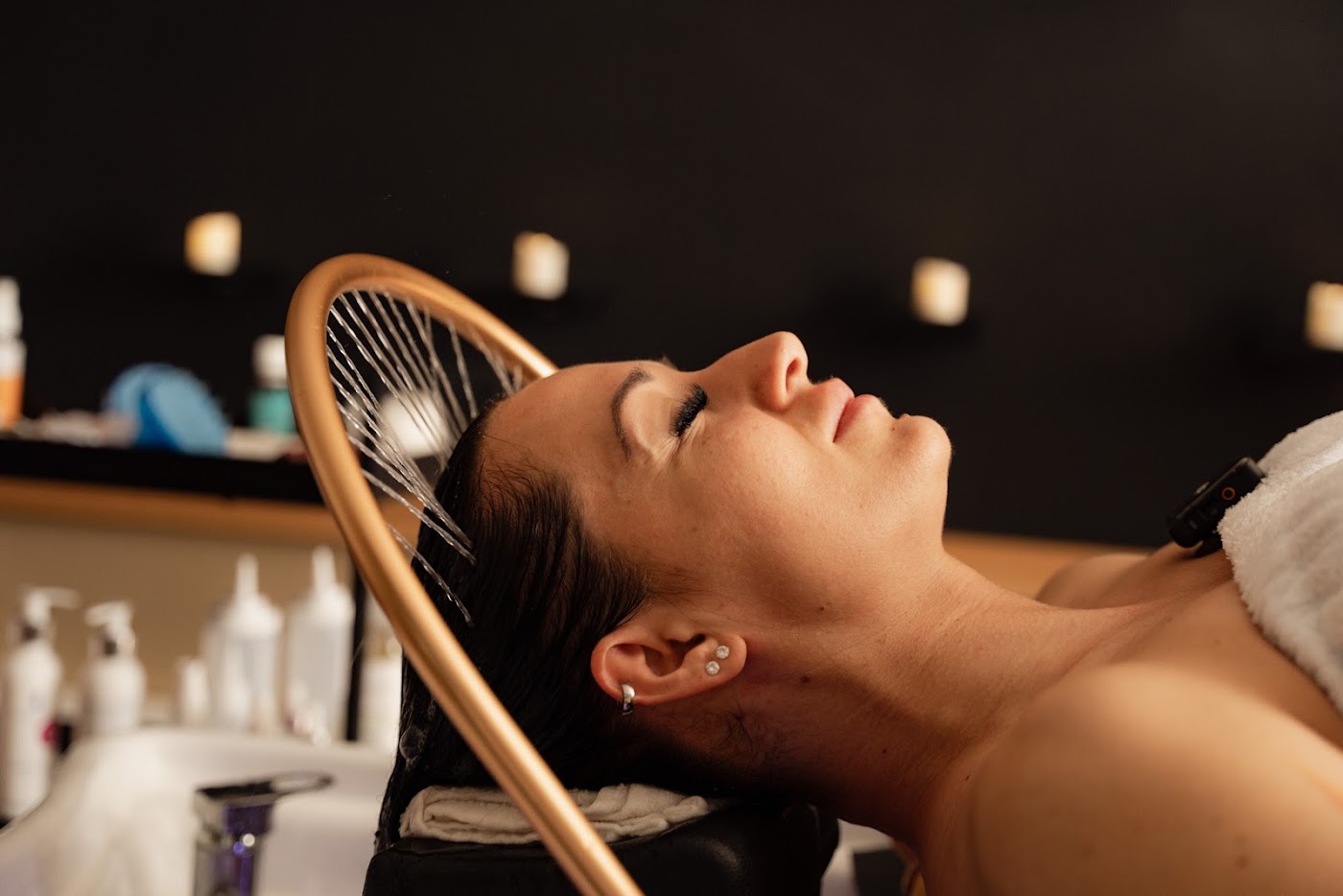 Vendég a Head Spa kezelésen, az arany körvízsugaras ív alatt